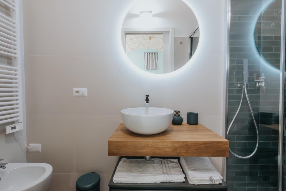 Il lavabo del bagno, con lo specchio rotondo illuminato