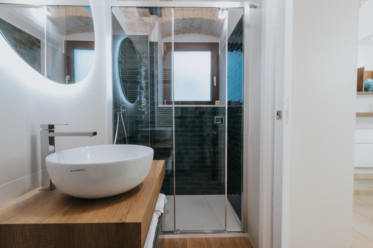 La doccia del bagno, con le piastrelle verde scuro